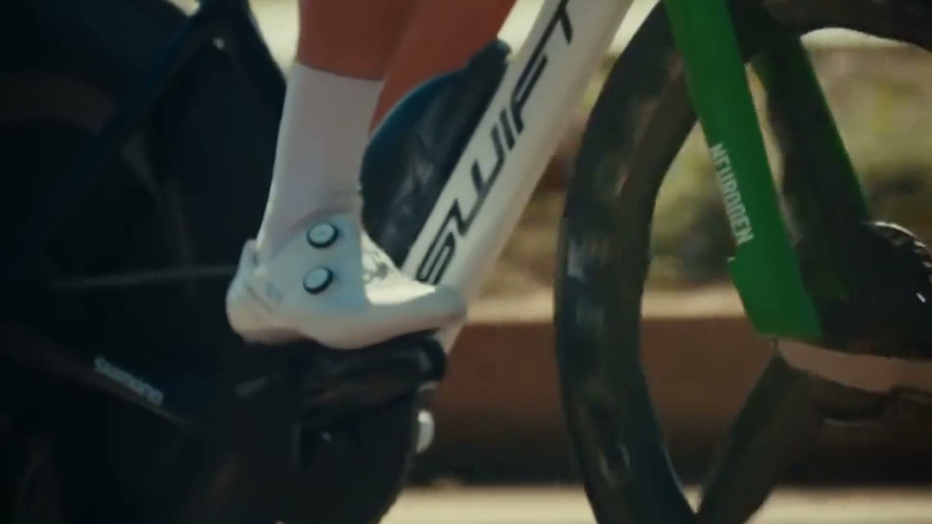 A Swift race bike up close at speed, rider's shoe on the pedal